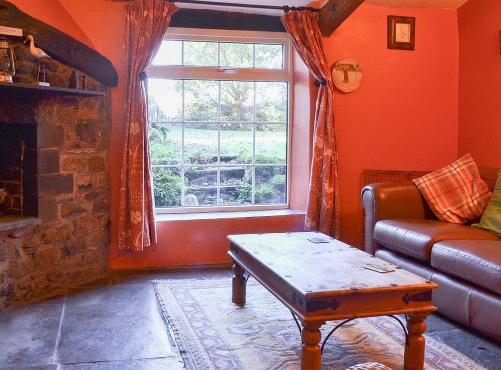 Slate-floored living room with open fireplace at Birkerthwaite Barn in Eskdale, Cumbria