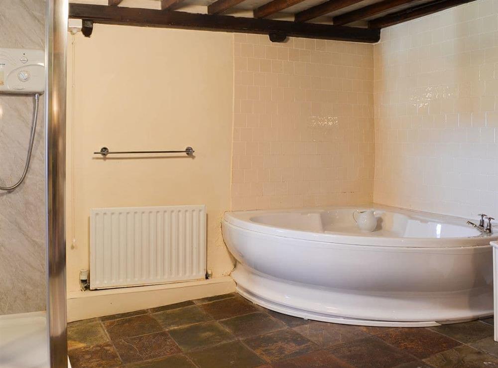 Soacious bathroom with corner bath and shower cubicle at Birkerthwaite Barn in Eskdale, Cumbria