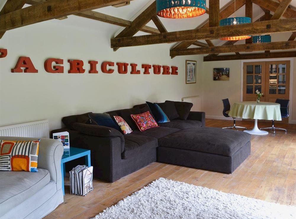 Spacious beamed living room with wood-burning stove at The Carriage House, 