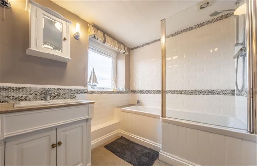 Bathroom with bath with shower over at Blackhorse Cottage, Brancaster Staithe near Kings Lynn