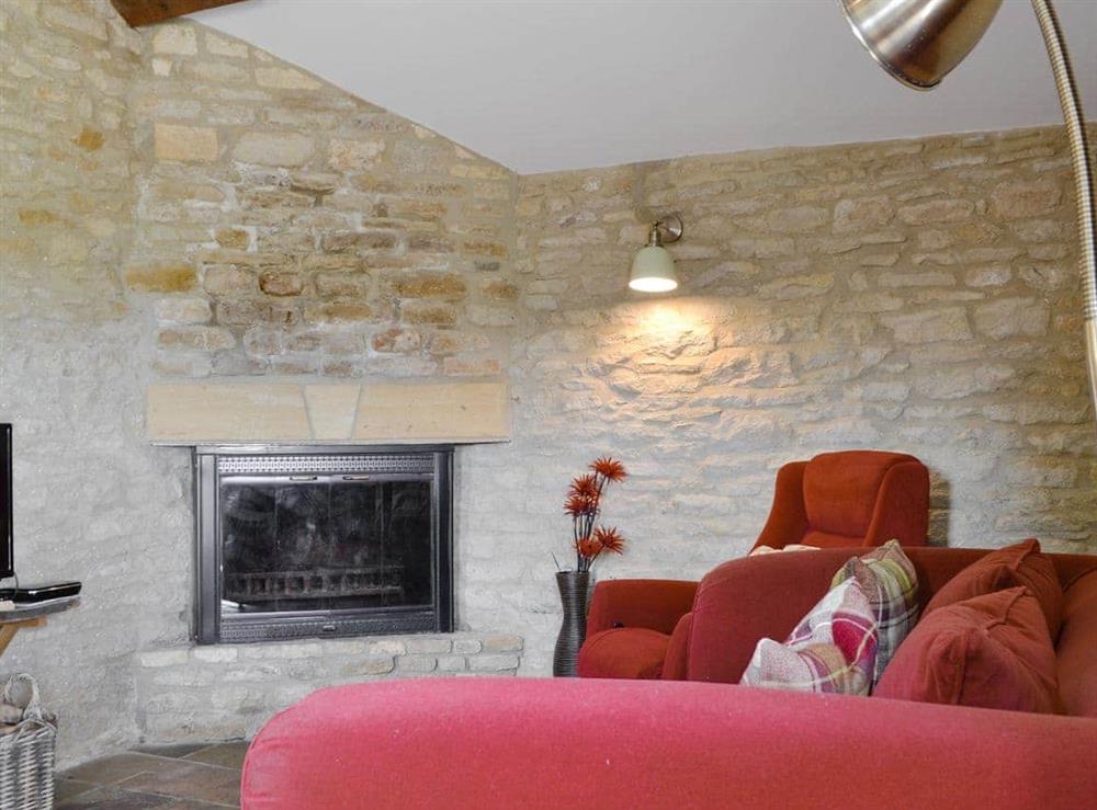 Characterful living room with an open fire at Stable Cottage, 