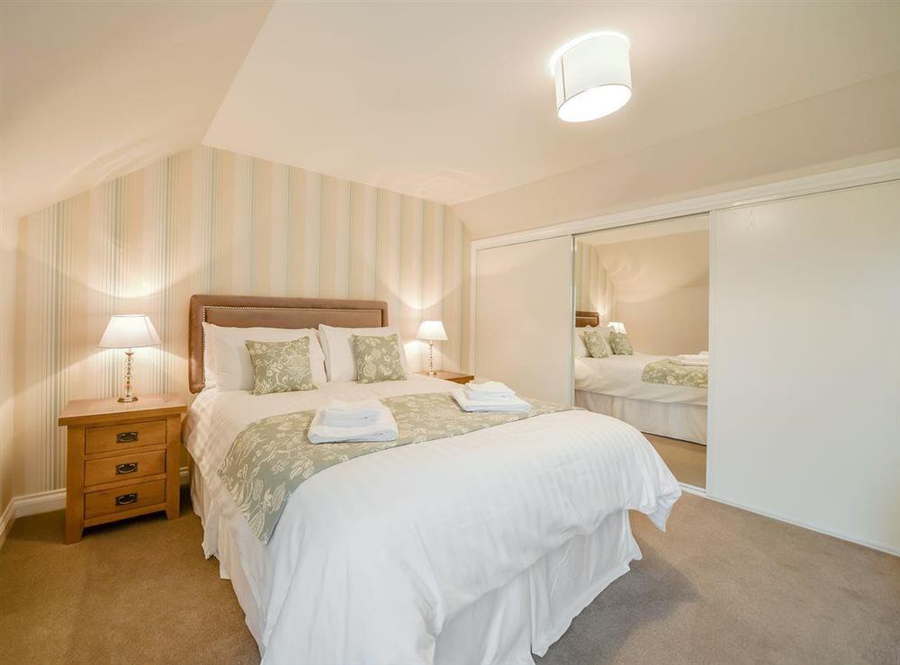 Stylish double bedroom with built-in wardrobes at McKenzie Cottage, 