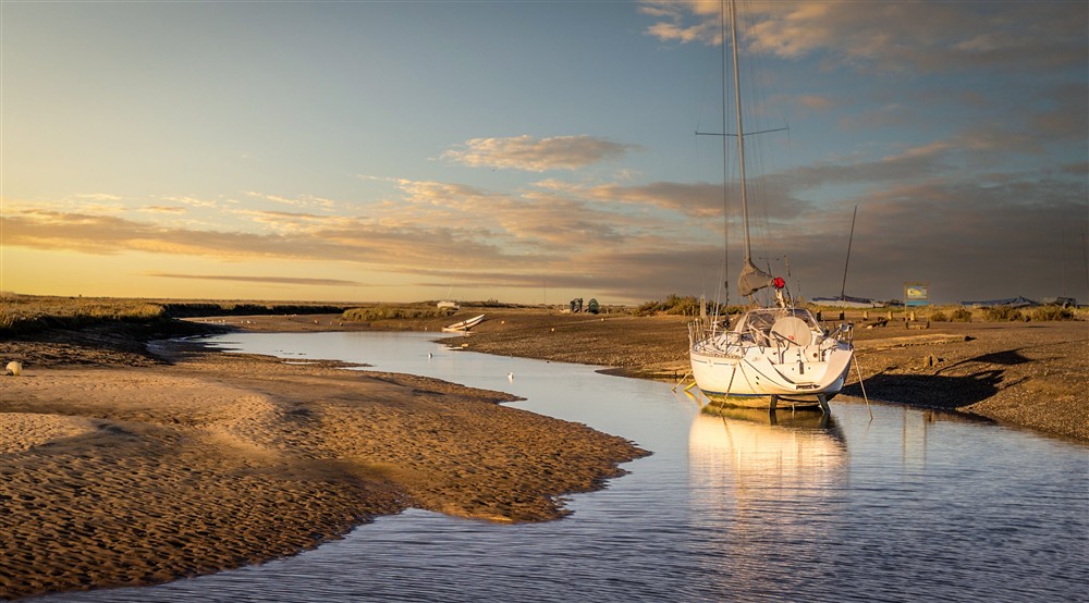 A boat docked on the tidal creeks at Blakeney Lodge in Blakeney, Norfolk