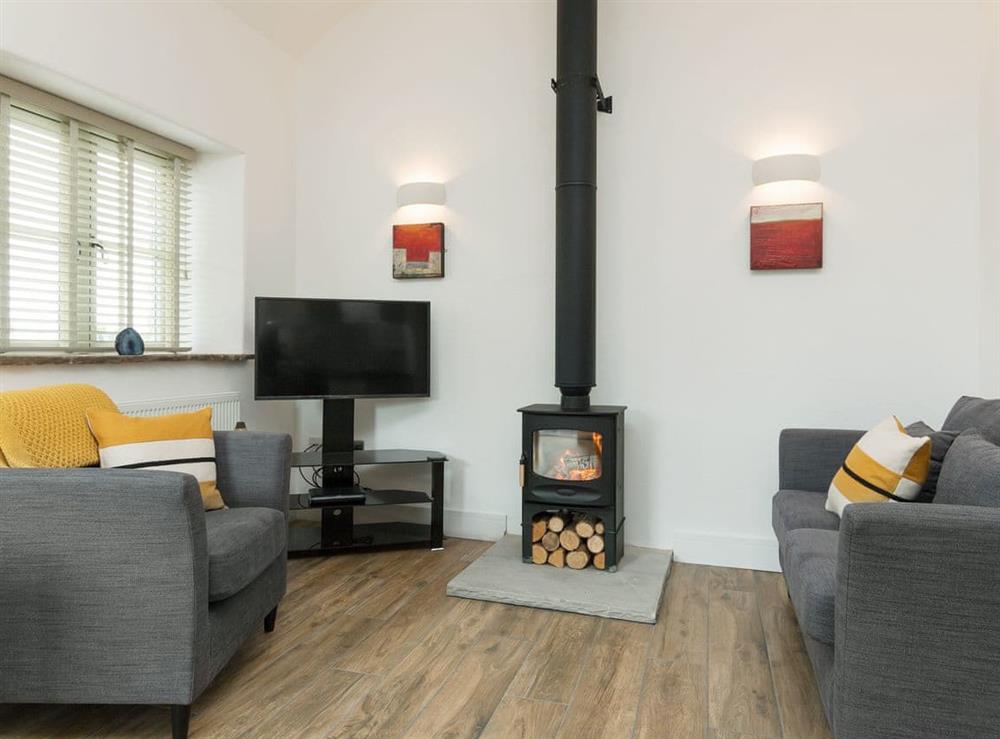 Stylishly furnished living area with cosy wood burner at Blakeskerra Barn in Kenfig, near Porthcawl, Glamorgan, Mid Glamorgan