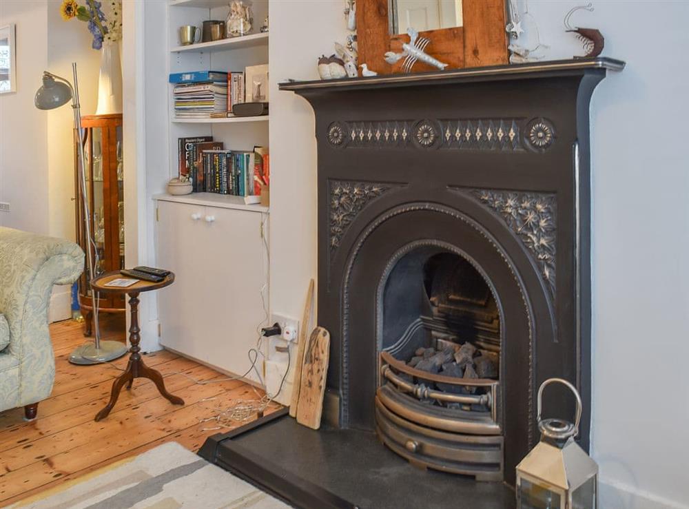 Warm and inviting living area with open fireplace at Blue Cottage in Broadstairs, England
