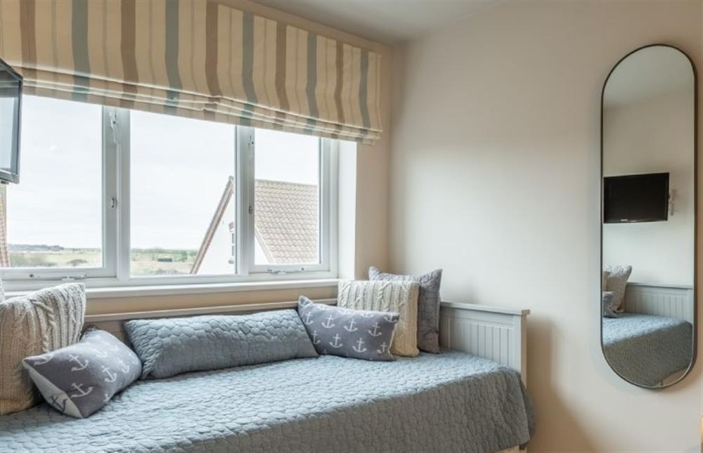 Second floor: Bedroom two with window seat offering a glimpse of the sea at Blue Sky, Wells-next-the-Sea