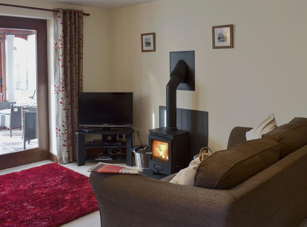 Comfortable living/ dining room with cosy wood burner at Bluebell Barn in Newbiggin on Lune, near Kirkby Stephen, Cumbria