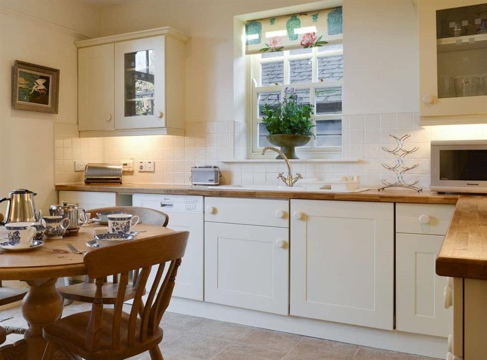 Well-equipped fitted kitchen with dining area at Bluebell Cottage in Grasmere, near Ambleside, Cumbria