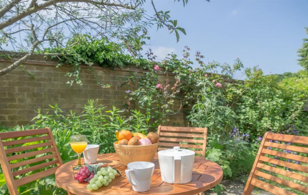 The garden is the perfect spot to enjoy breakfast in the sunshine at Bluebell Cottage, Hindringham, Fakenham