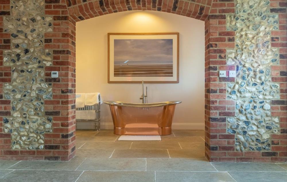 Archway from the master bedroom to a stunning copper bath at Bodney Lodge, Bodney