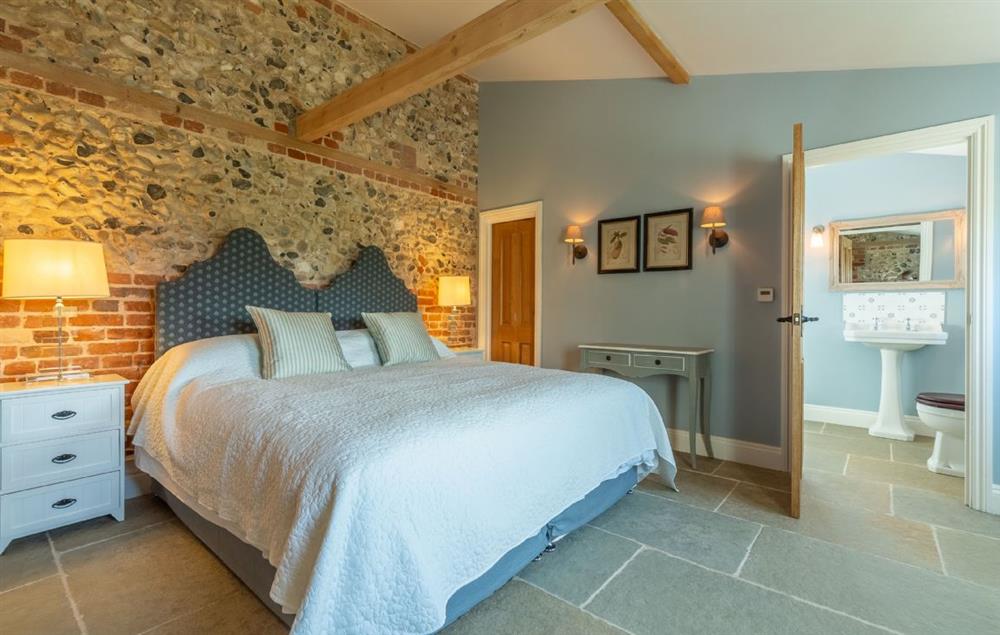 Bedroom with 6’ super king size bed and en-suite bathroom at Bodney Lodge, Bodney