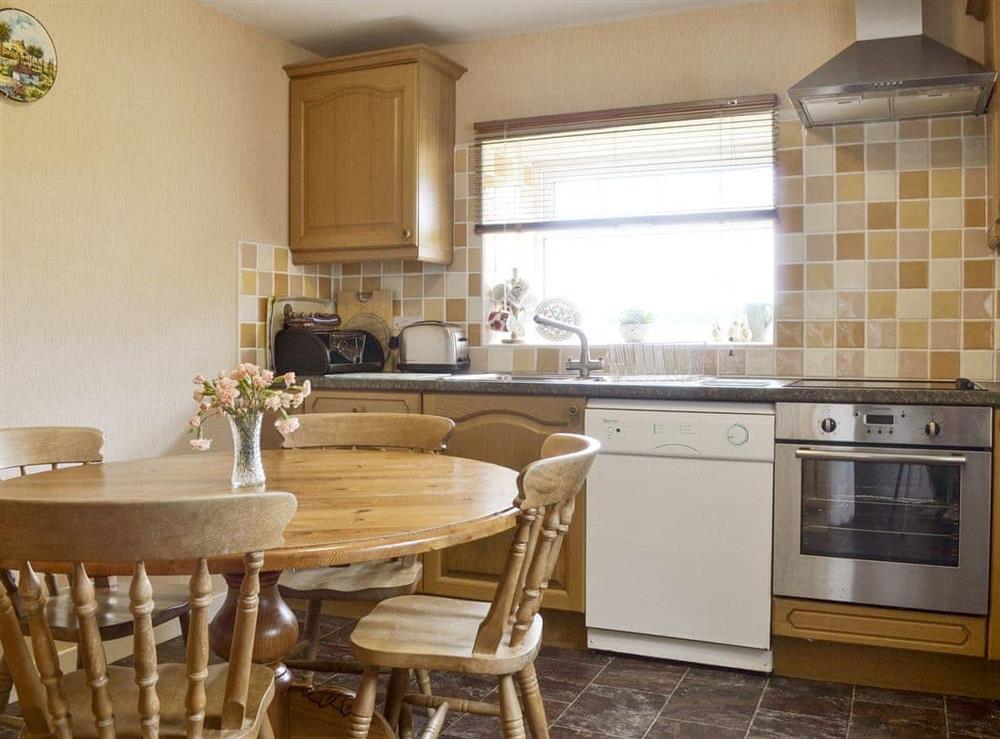Well-equipped kitchen with dining area at Bodwi Isaf in near Abersoch, Gwynedd