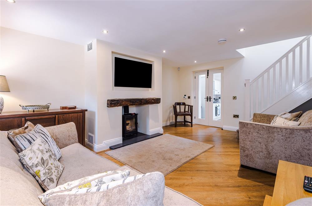 The bright and airy sitting room boasts a wood burning stove and sumptuous seating