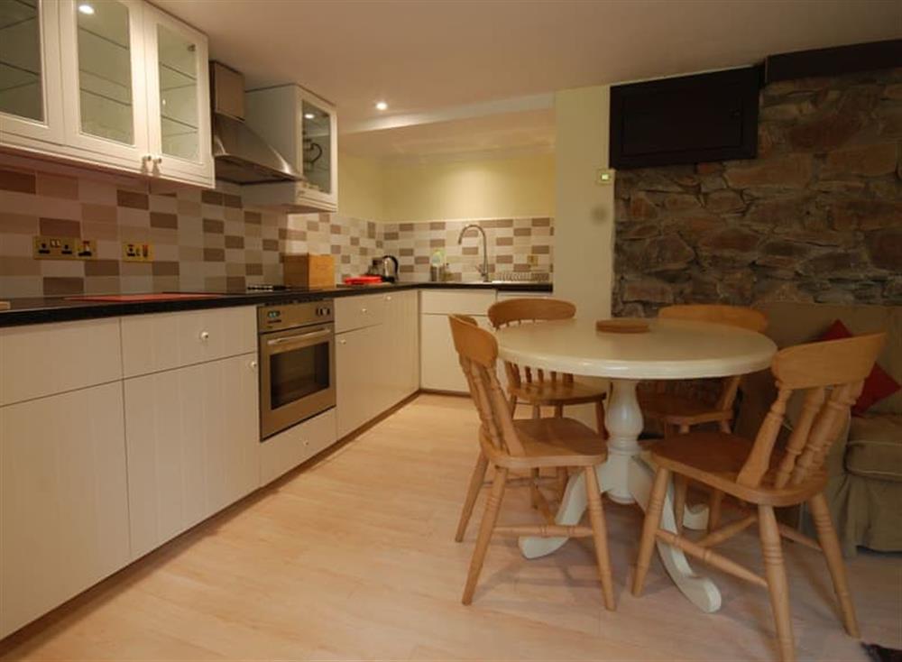Fully equipped kitchen with dining area within the open-plan design at Garden Cottage, 