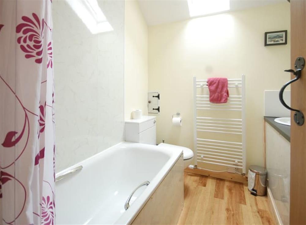 Family bathroom with shower over bath at Holly Cottage, 