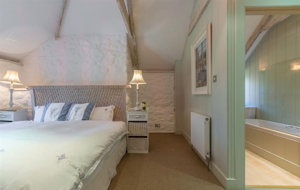 Double bedroom with 6’ super-king bed and bathroom opposite with bath and shower over (photo 2) at Bonython Farmhouse, Helston