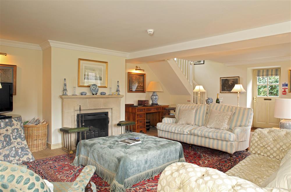The comfortable sitting room boasts an open fire at Bookers Cottage, Bruern, near Chipping Norton