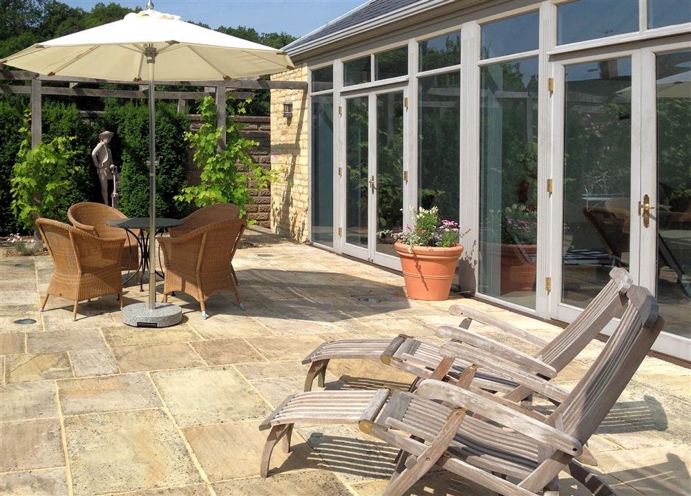 The pretty outdoor seating area, by the pool  at Bookers Cottage, Bruern, near Chipping Norton