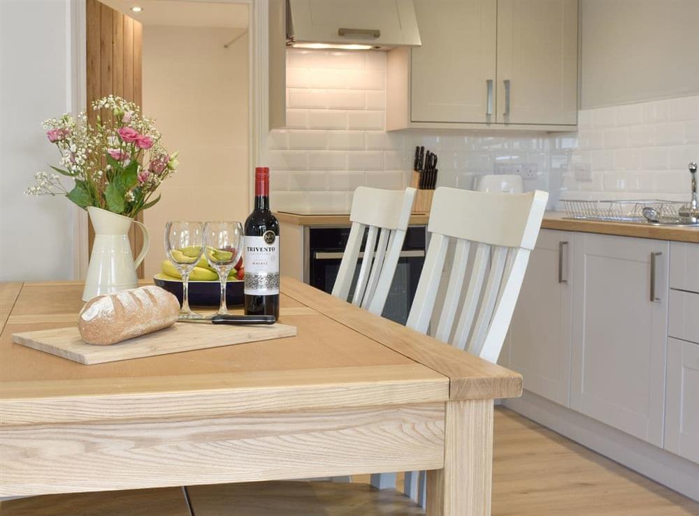 Fully equipped kitchen with dining area within the open-plan design at Threagill Cottage, 