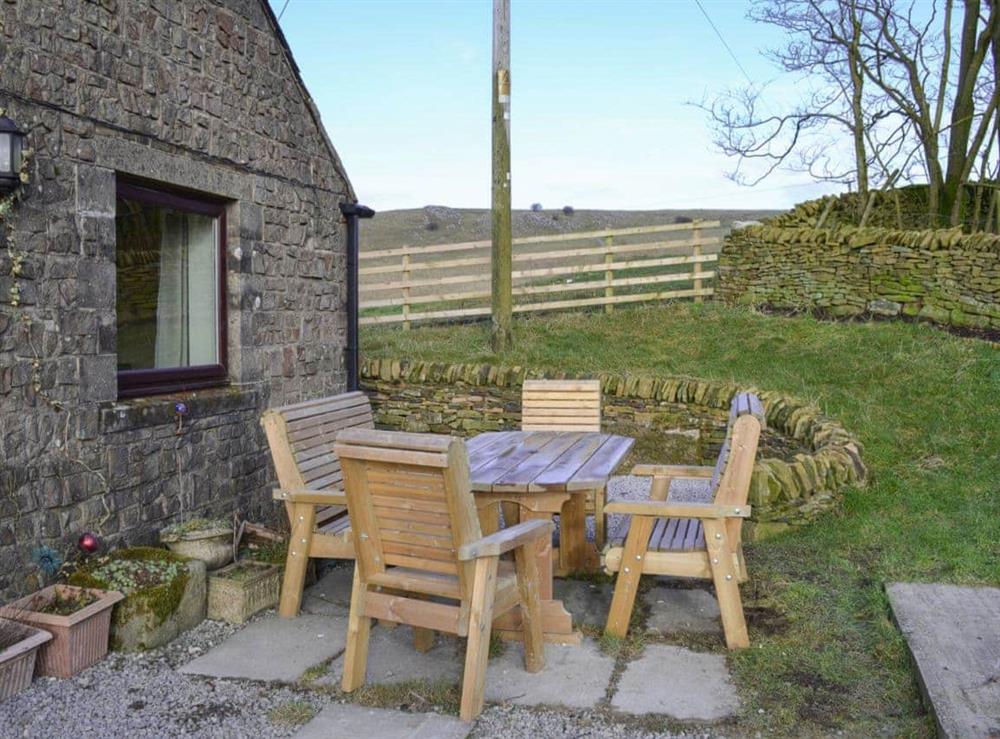 Paved patio with table and chairs for alfresco dining at Booth Farm Bungalow in Buxton, Derbyshire