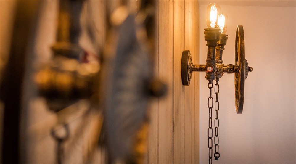 Light fixtures made from old farming equipment in the double bedroom at Bosigran Cottage in Penzance, Cornwall
