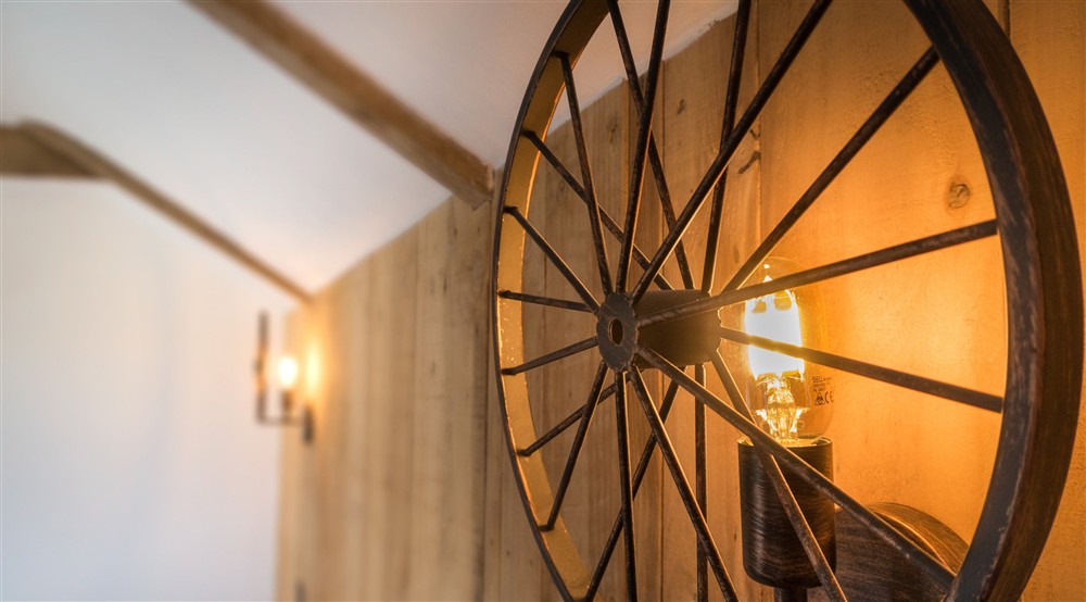 Light fixtures made from old farming equipment in the twin bedroom at Bosigran Cottage in Penzance, Cornwall