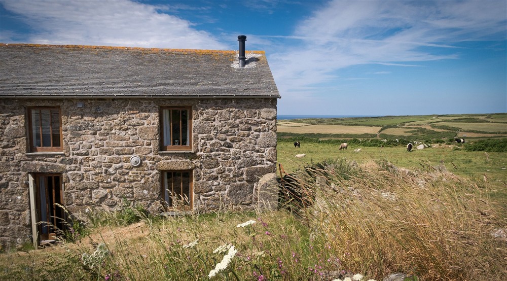 The exterior of Bosigran Cottage with fields in the background, Cornwall at Bosigran Cottage in Penzance, Cornwall