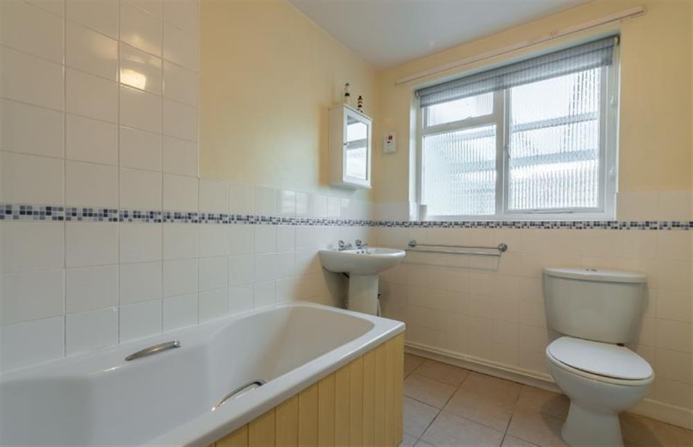 Bathroom with bath and shower over, wash basin and WC at Bovis Cottage, Southwold