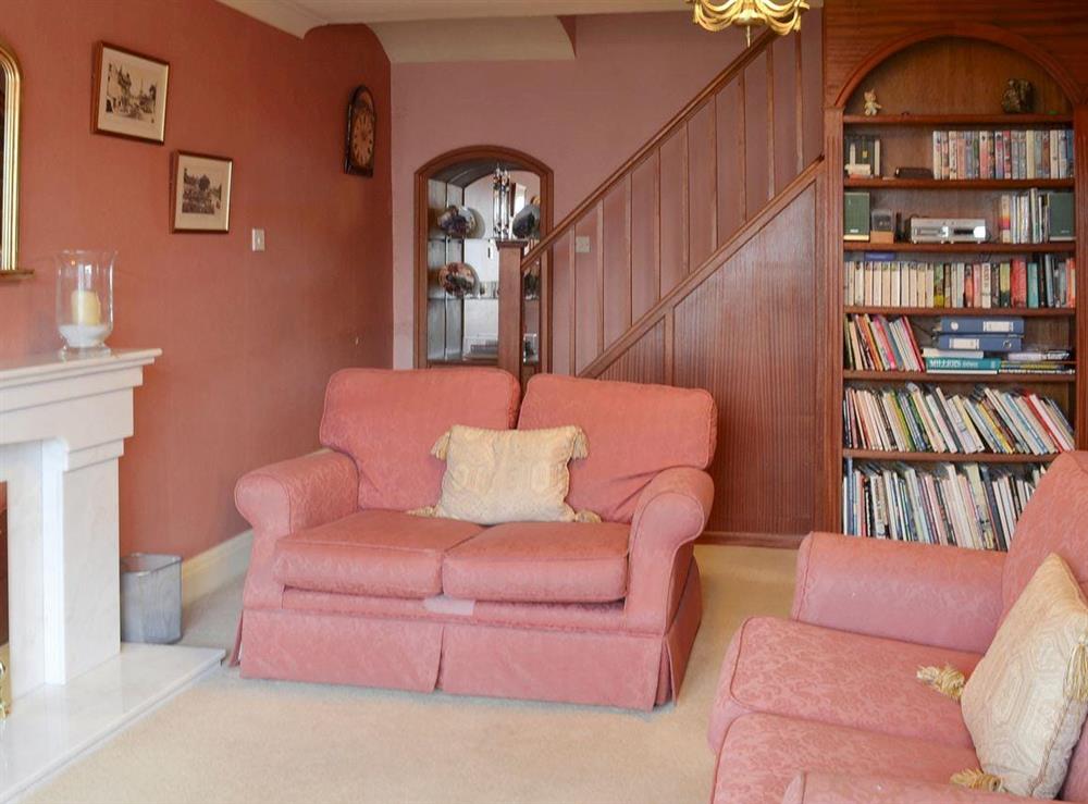 Comfy seating and stairs to first floor in living room at Bow Cottage in Pickering, North Yorkshire