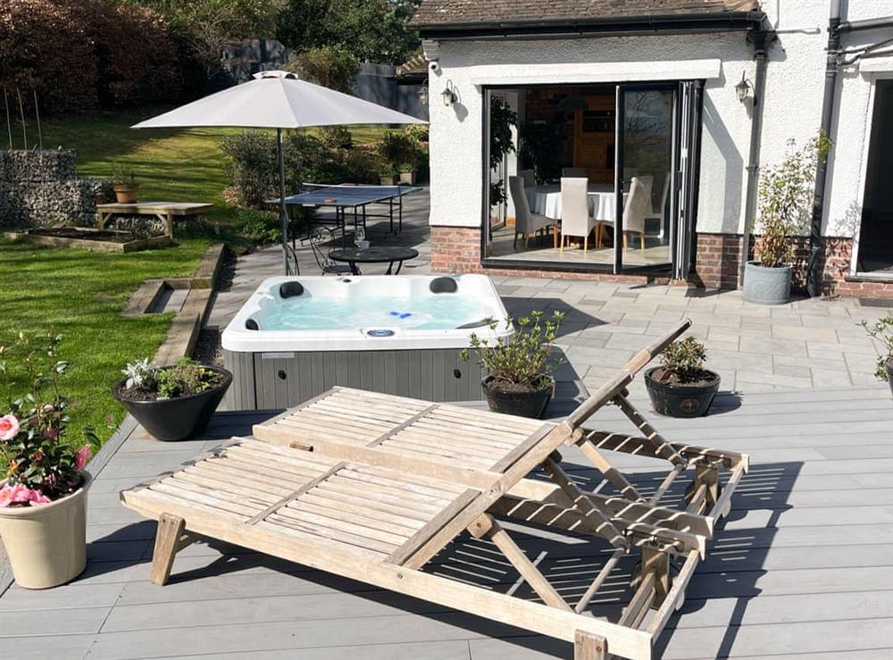 Patio with hot tub and sun loungers at Brackenwood in Caldy, near West Kirby, Merseyside