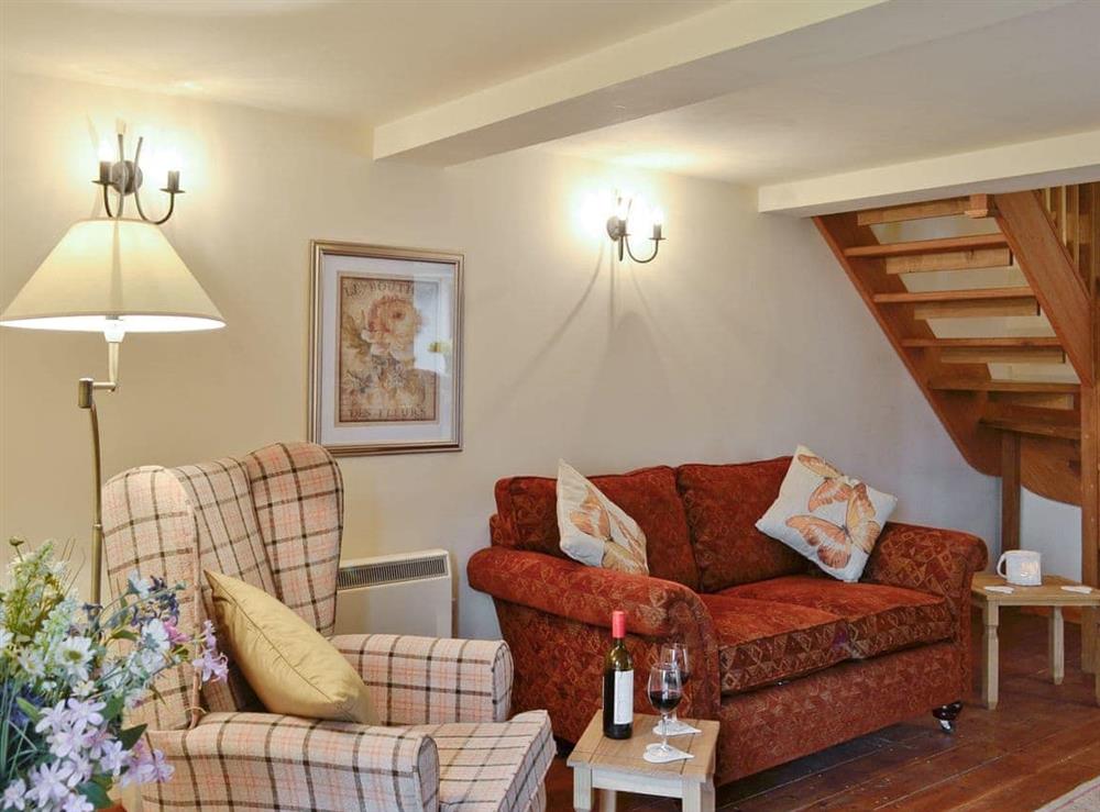 Comfy lounge with access to stairs to upper level at Bramble Cottage, 