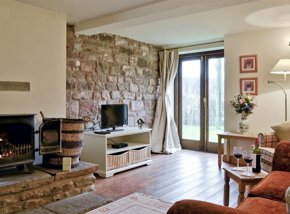 Cosy lounge with wood-burner and patio doors at Bramble Cottage, 