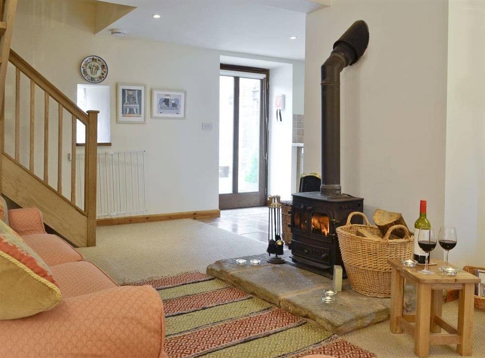Lounge with wood-burner and patio doors at Honey Cottage, 
