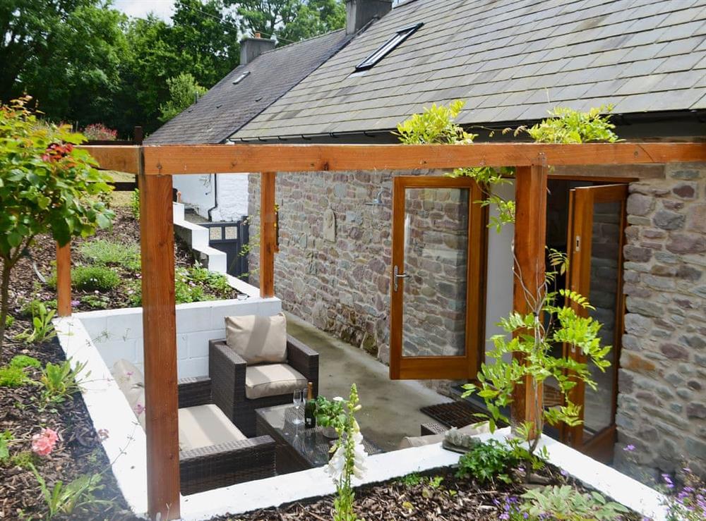 Enclosed garden with patio, garden furniture and fire pit at Bramble Cottage in Llanddeusant, near Llangadog, Carmarthenshire, Dyfed