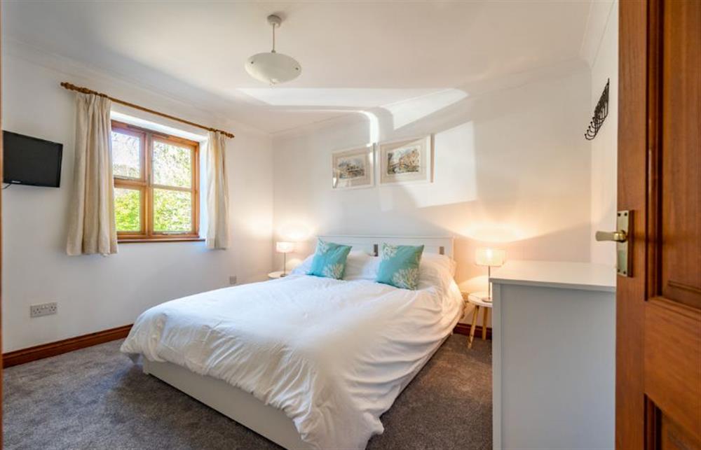 Ground floor: Master bedroom with king-size bed at Brambles, Brancaster Staithe near Kings Lynn