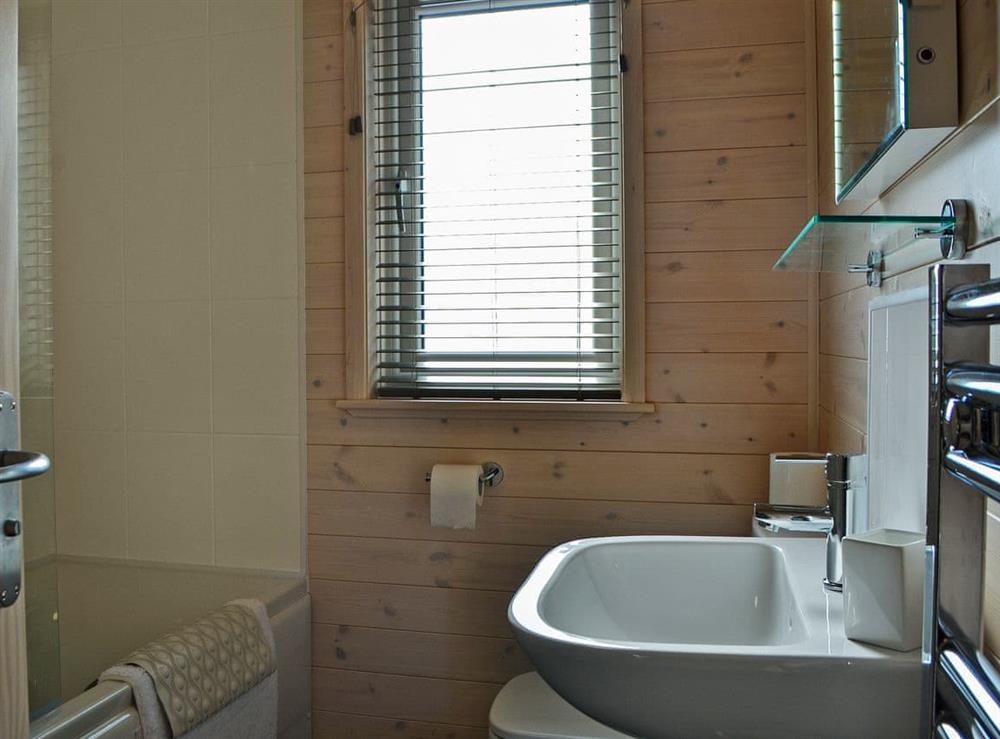 Bathroom with full sized bath with a shower at Bransty in Burnside Park, Cumbria
