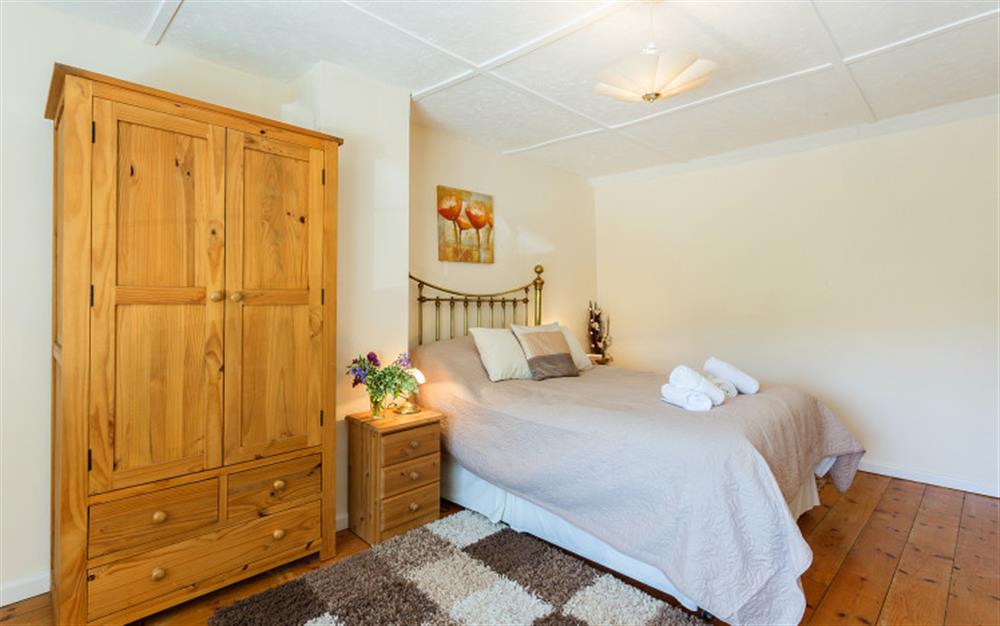 Bedroom 1 with 4ft 6inch double bed and wardrobe at Bridge Cottage in Powerstock