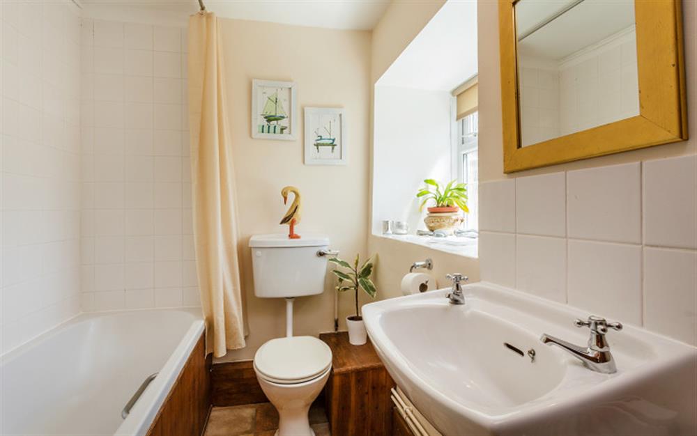 Ground floor family bathroom with shower over bath w.c. and basin at Bridge Cottage in Powerstock