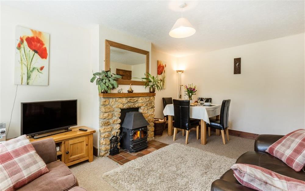 Lounge area with seating for 4, flatscreen tv and log burner  at Bridge Cottage in Powerstock
