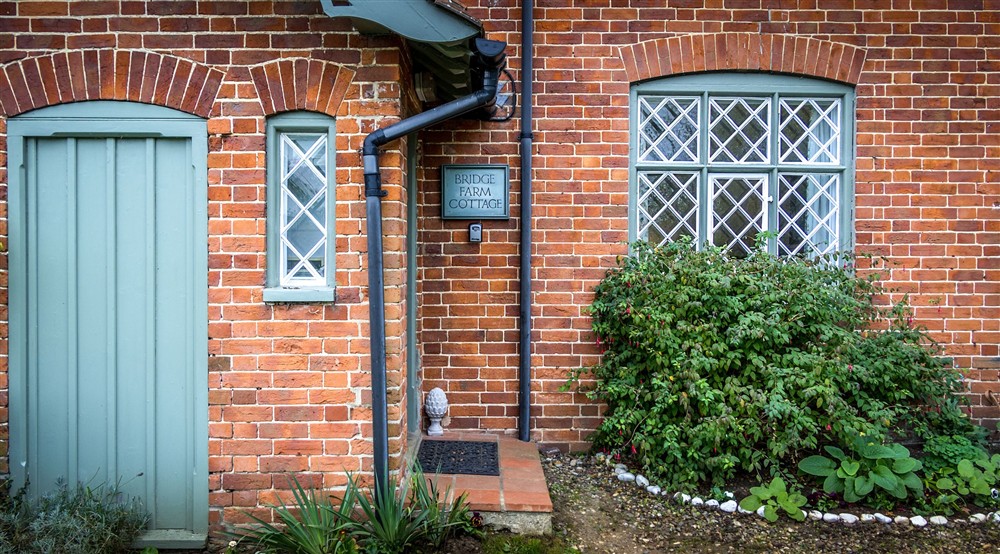 The front of Bridge Farm Cottage, showing the step up to the front door, Suffolk