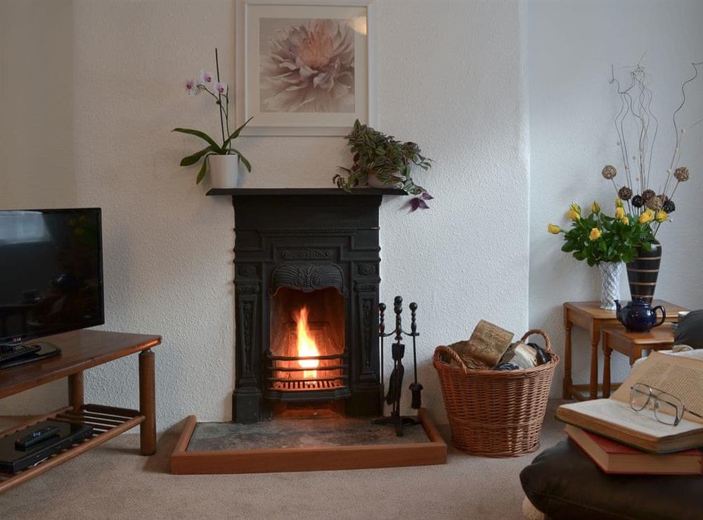 Living room with open fire at Bridgend Cottage in Lostwithiel, Cornwall