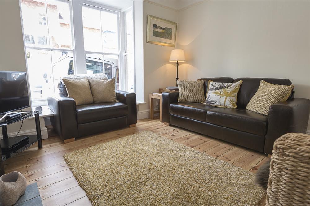 Cosy sitting room with leather sofa and love chair