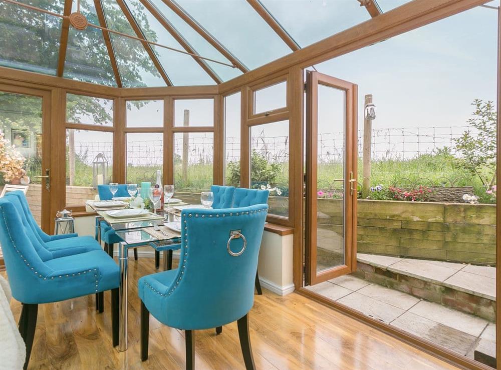 Dining area within the conservatory with access to the garden at Brittons Hill Cottage in Kenardington, near Ashford, Kent