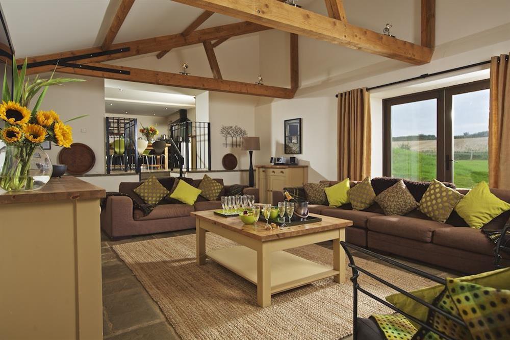 The sitting room has double doors to terrace and garden at Broad Downs Barn in Malborough, Nr Salcombe