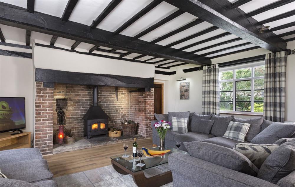 Spacious sitting room with inglenook fireplace and wood burning stove (photo 2) at Broad Meadows Farmhouse, Bayton