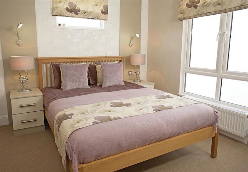 Double bedroom in a Country Lodge Four VIP Platinum at Brokerswood Holiday Park in Southwick, Wiltshire