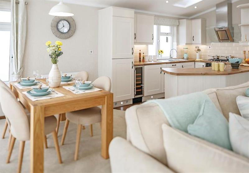 The living area/dining area and kitchen in a Country Lodge Four VIP Platinum at Brokerswood Holiday Park in Southwick, Wiltshire