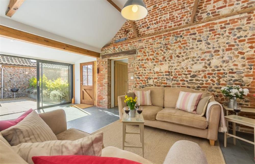 Ground floor:  Sitting area with feature exposed brick wall at Bromholm Barn, Ridlington near Norwich