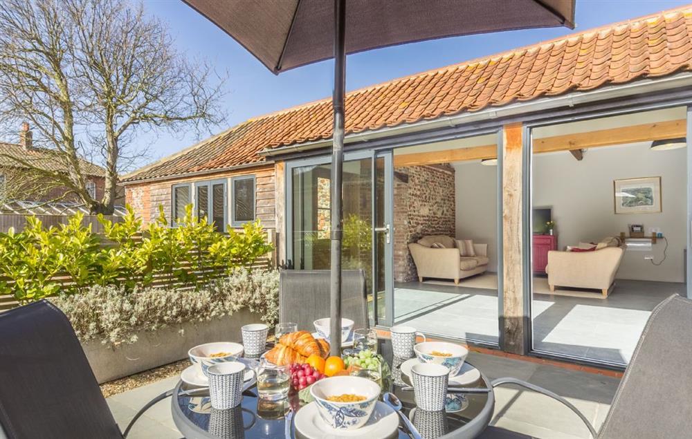 Sliding glass doors from sitting room lead onto a private, South facing courtyard at Bromholm Barn, Ridlington