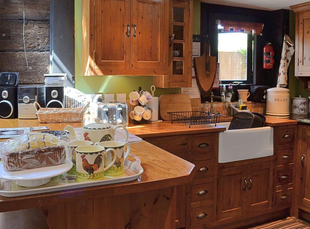 The property features a traditional handmade kitchen with wood topped breakfast bar at Brook Barn in Shobley, Ringwood, Hants., Hampshire
